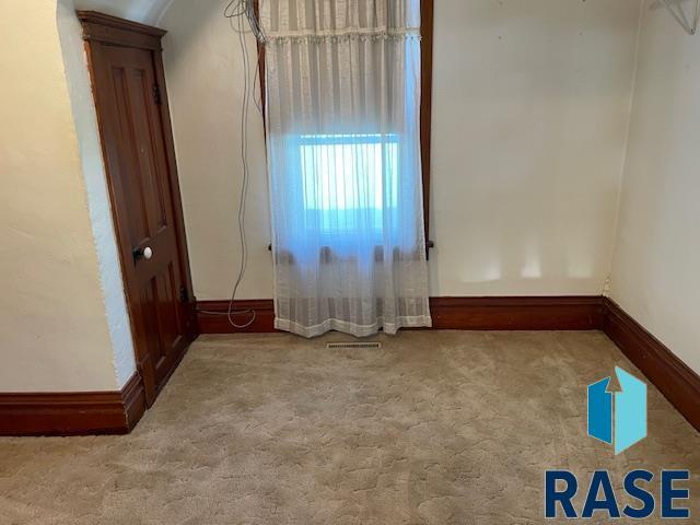 1131 Williams St, Larchwood, IA 51241 - carpeted empty room featuring baseboards