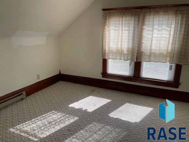 1131 Williams St, Larchwood, IA 51241 - bonus room with a baseboard heating unit, carpet floors, lofted ceiling, and baseboards