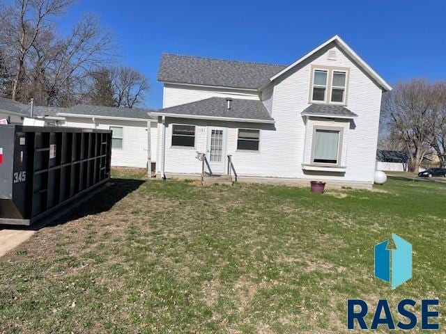 1131 Williams St, Larchwood, IA 51241 - back of property featuring a lawn, roof with shingles, and entry steps
