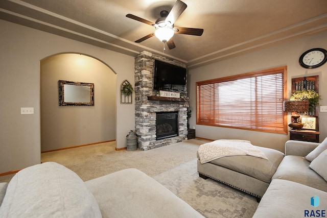 7304 W Lobelia St, Sioux Falls, SD 57106 - carpeted living area with arched walkways, baseboards, a ceiling fan, and a stone fireplace