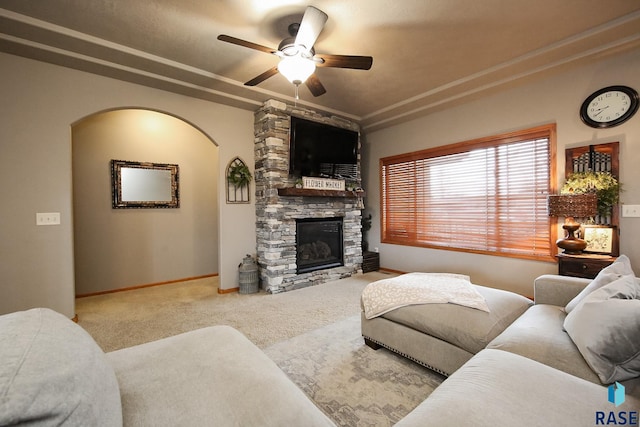 7304 W Lobelia St, Sioux Falls, SD 57106 - carpeted living room featuring arched walkways, ceiling fan, a stone fireplace, and baseboards