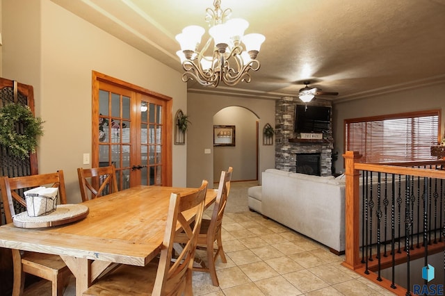 7304 W Lobelia St, Sioux Falls, SD 57106 - dining area featuring ornamental molding, light tile patterned flooring, a stone fireplace, arched walkways, and ceiling fan with notable chandelier
