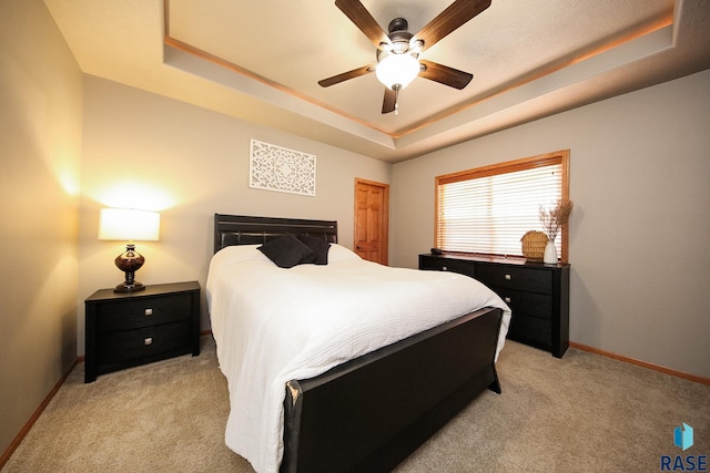 7304 W Lobelia St, Sioux Falls, SD 57106 - bedroom featuring baseboards, a ceiling fan, a tray ceiling, and light colored carpet
