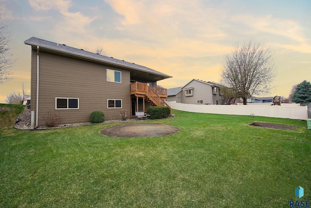 7304 W Lobelia St, Sioux Falls, SD 57106 - back of property at dusk with a lawn, fence, stairway, and a deck