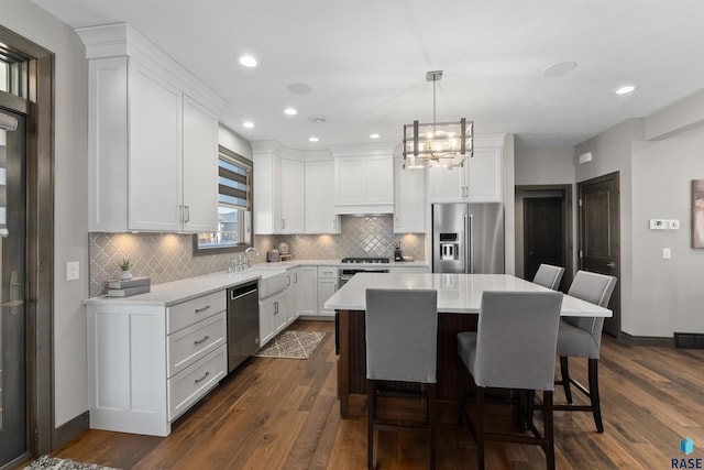 912 Torrey Pine Ln, Sioux Falls, SD 57110 - kitchen featuring stainless steel appliances, custom range hood, light countertops, a kitchen bar, and dark wood finished floors