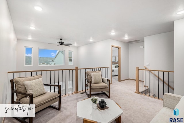 sitting room with light carpet, a ceiling fan, recessed lighting, and an upstairs landing