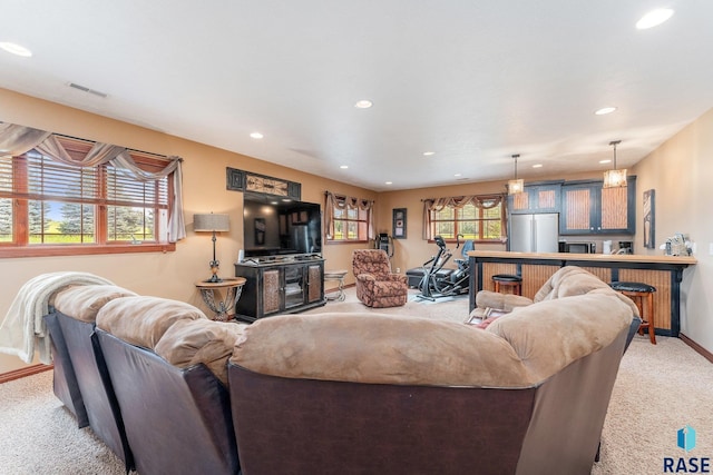 living area with visible vents, baseboards, recessed lighting, and light colored carpet