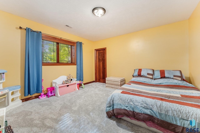bedroom with baseboards, visible vents, and carpet
