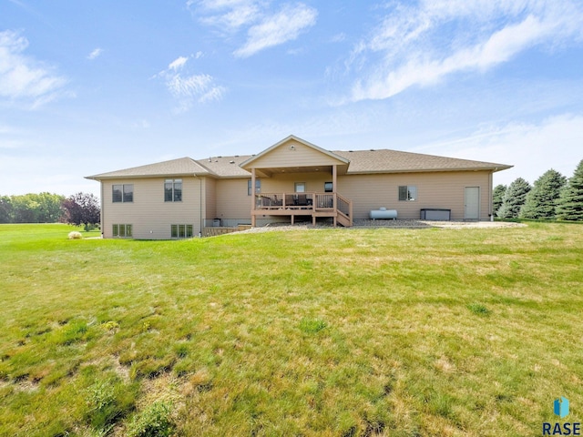 rear view of property with a yard and a deck