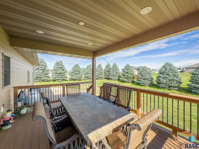 wooden terrace with a lawn and outdoor dining area