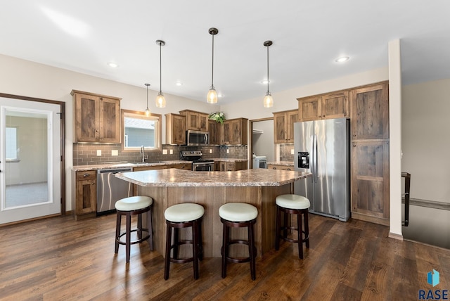 3508 E Prairie Wind St, Sioux Falls, SD 57108 - kitchen featuring stainless steel appliances, a center island, a sink, backsplash, and a breakfast bar