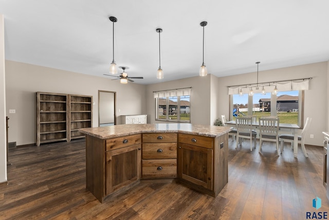 3508 E Prairie Wind St, Sioux Falls, SD 57108 - kitchen with decorative light fixtures, a ceiling fan, dark wood-style floors, and a kitchen island