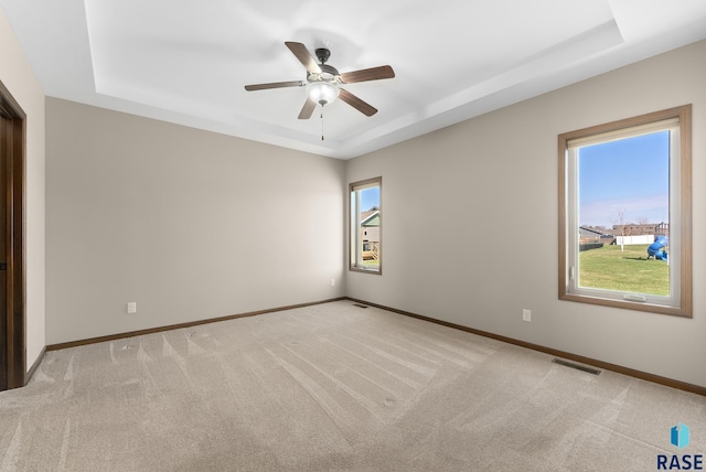 3508 E Prairie Wind St, Sioux Falls, SD 57108 - unfurnished room with light carpet, a ceiling fan, baseboards, and a raised ceiling
