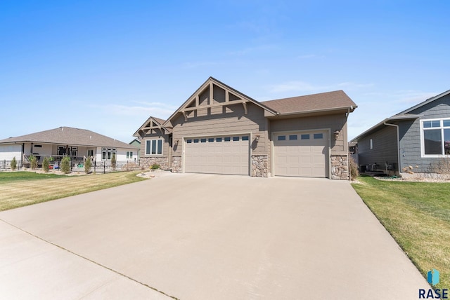 3508 E Prairie Wind St, Sioux Falls, SD 57108 - craftsman-style house featuring a front lawn, stone siding, concrete driveway, fence, and an attached garage