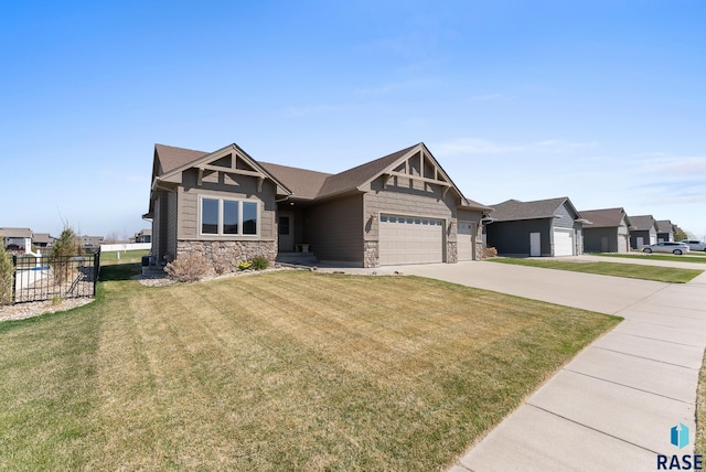 3508 E Prairie Wind St, Sioux Falls, SD 57108 - craftsman-style home with fence, an attached garage, driveway, stone siding, and a front yard