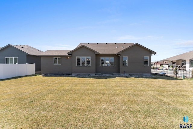 3508 E Prairie Wind St, Sioux Falls, SD 57108 - rear view of property with roof with shingles, fence, and a yard