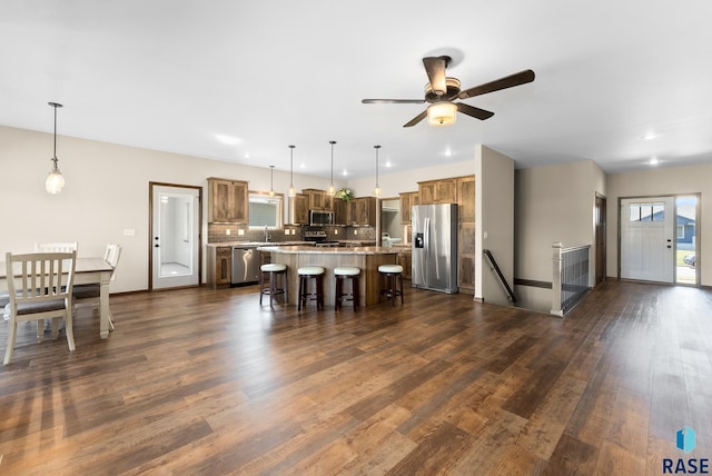 3508 E Prairie Wind St, Sioux Falls, SD 57108 - kitchen with a ceiling fan, a kitchen island, light countertops, a breakfast bar, and appliances with stainless steel finishes