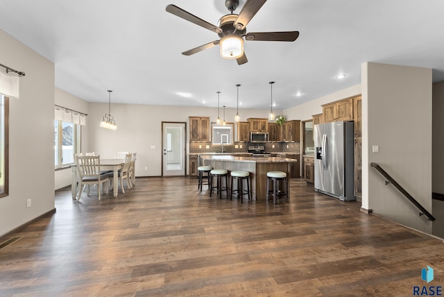 3508 E Prairie Wind St, Sioux Falls, SD 57108 - kitchen featuring a center island, decorative backsplash, ceiling fan, a kitchen bar, and appliances with stainless steel finishes