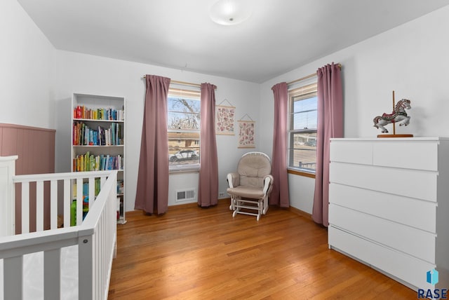 bedroom with light wood finished floors, multiple windows, and visible vents