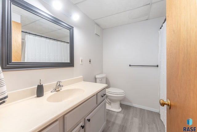 full bath featuring baseboards, wood finished floors, toilet, and vanity