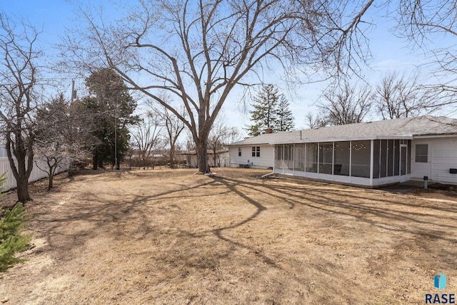 view of yard featuring a sunroom and fence