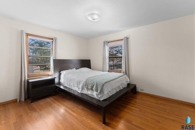 bedroom with light wood-style flooring and baseboards