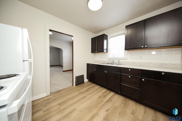 1330 W 14th St, Sioux Falls, SD 57104 - kitchen with backsplash, range, light countertops, and a sink