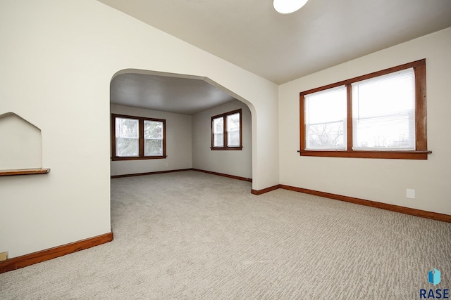 1330 W 14th St, Sioux Falls, SD 57104 - spare room with arched walkways, lofted ceiling, baseboards, and light carpet