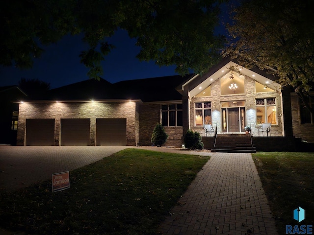6301 S Grand Prairie Dr, Sioux Falls, SD 57108 - view of front of home featuring an attached garage, driveway, stone siding, and a lawn