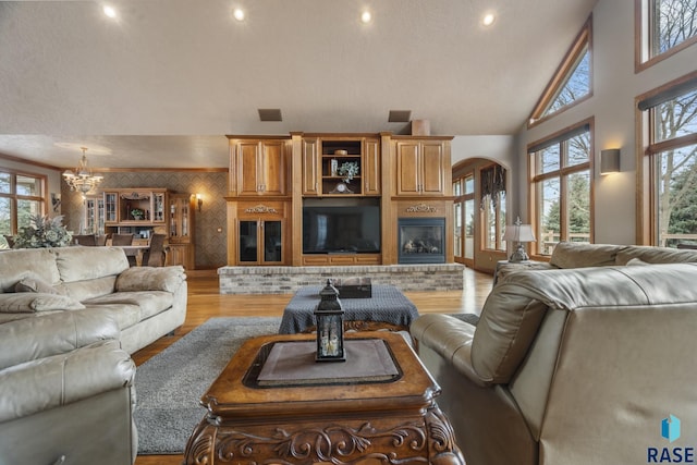 6301 S Grand Prairie Dr, Sioux Falls, SD 57108 - living area with high vaulted ceiling, arched walkways, light wood finished floors, visible vents, and recessed lighting