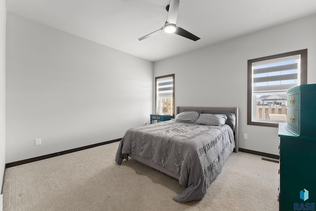 bedroom with carpet floors, visible vents, a ceiling fan, and baseboards