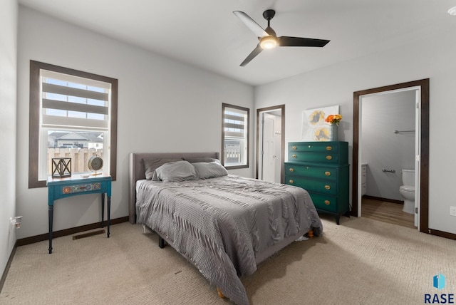 bedroom featuring light carpet, baseboards, and multiple windows