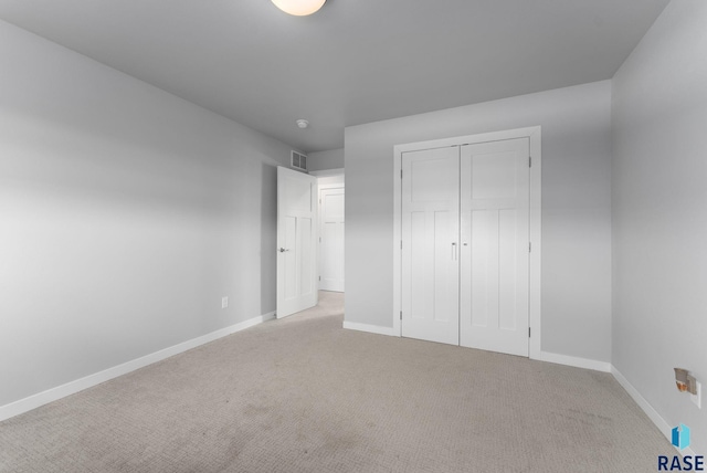 unfurnished bedroom featuring a closet, carpet flooring, and baseboards