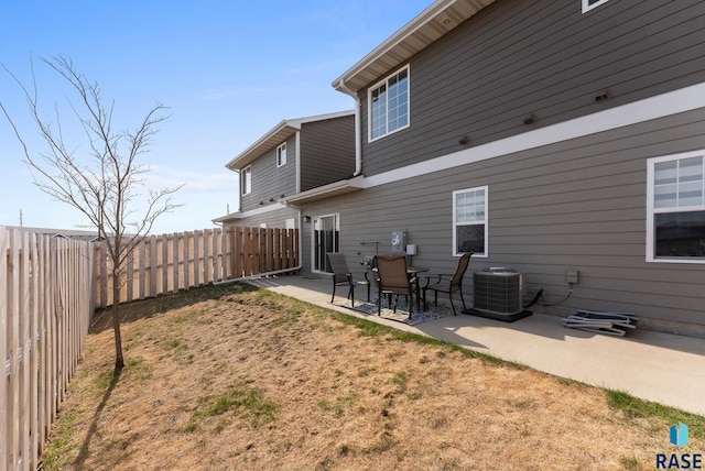 rear view of house with a patio area, a fenced backyard, and central AC unit