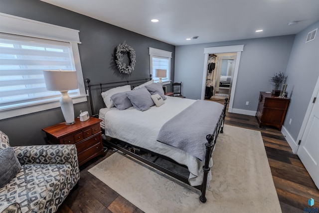 bedroom with dark wood-type flooring, visible vents, baseboards, and recessed lighting