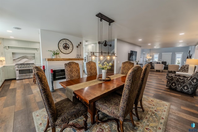 dining area with a glass covered fireplace, visible vents, recessed lighting, and dark wood-type flooring