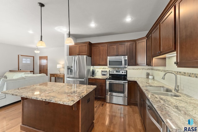 5508 S Sirocco Ave, Sioux Falls, SD 57108 - kitchen featuring stainless steel appliances, wood finished floors, a sink, and tasteful backsplash