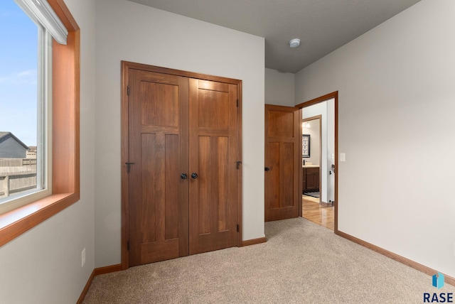 5508 S Sirocco Ave, Sioux Falls, SD 57108 - unfurnished bedroom featuring light carpet, a closet, and baseboards