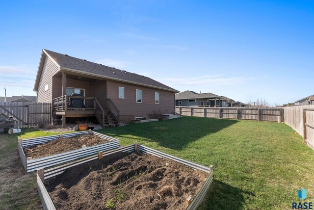 5508 S Sirocco Ave, Sioux Falls, SD 57108 - back of property with a fenced backyard, a lawn, a vegetable garden, and a deck