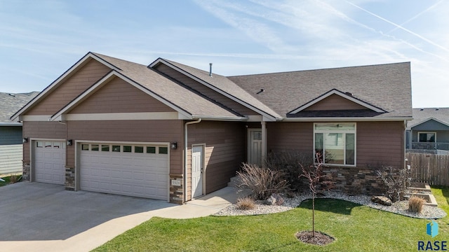 5508 S Sirocco Ave, Sioux Falls, SD 57108 - view of front of house with concrete driveway, stone siding, an attached garage, a front yard, and roof with shingles