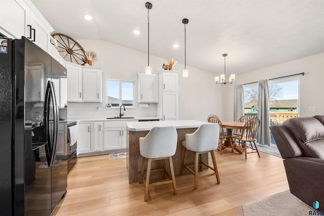 812 Sarah C Cir, Garretson, SD 57030 - kitchen featuring a sink, a healthy amount of sunlight, black fridge, open floor plan, and a notable chandelier