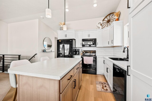 812 Sarah C Cir, Garretson, SD 57030 - kitchen featuring a center island, a sink, black appliances, decorative backsplash, and light wood-style flooring