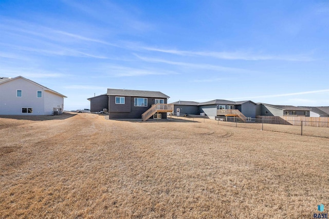 812 Sarah C Cir, Garretson, SD 57030 - back of property with a residential view, cooling unit, fence, a lawn, and stairway