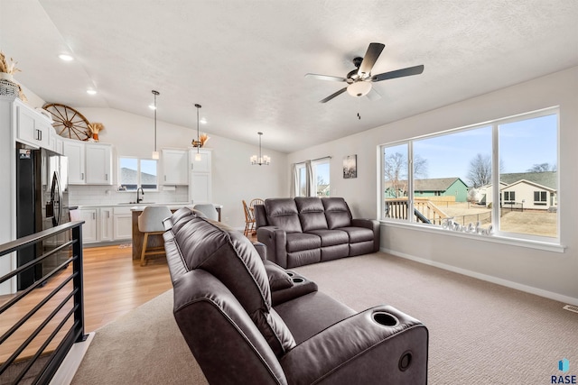 812 Sarah C Cir, Garretson, SD 57030 - living room featuring recessed lighting, vaulted ceiling, visible vents, light colored carpet, and ceiling fan with notable chandelier