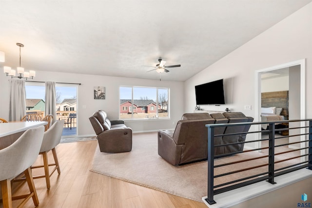 812 Sarah C Cir, Garretson, SD 57030 - living area with ceiling fan with notable chandelier, vaulted ceiling, baseboards, and light wood finished floors