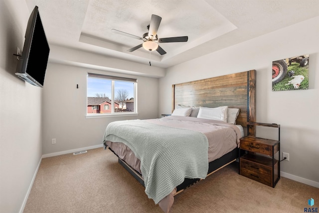 812 Sarah C Cir, Garretson, SD 57030 - bedroom with a ceiling fan, a tray ceiling, light colored carpet, baseboards, and visible vents