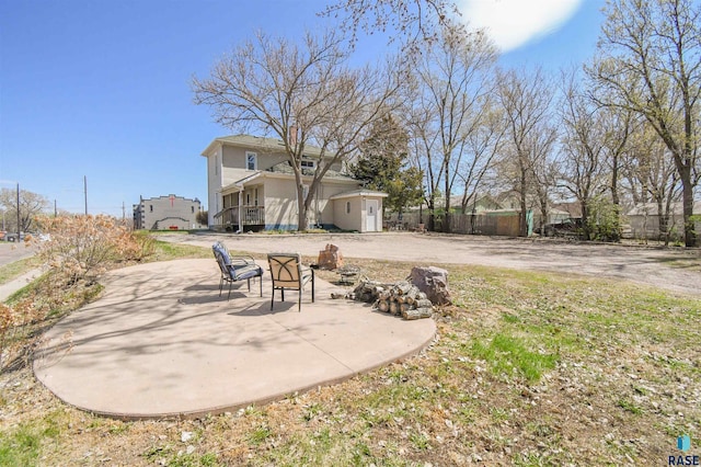 view of yard with a patio area, fence, and a fire pit