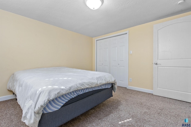 carpeted bedroom with a closet and baseboards