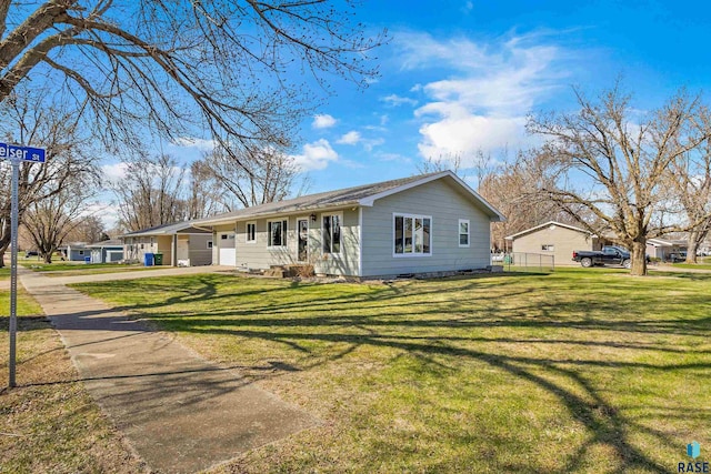 ranch-style house featuring driveway and a front lawn