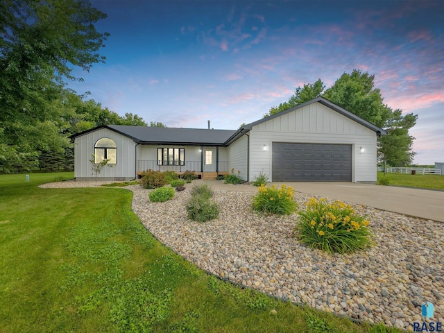 ranch-style house with a garage, board and batten siding, a front lawn, and concrete driveway